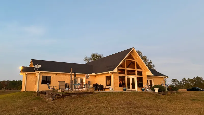 The same A-frame home at sunset with its finished shingle roof